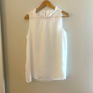 Women’s white sleeveless blouse with ruffle neckline. Size Medium.
